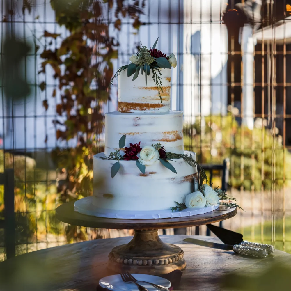 closeup-shot-beautiful-cake-table-decorated-openair-wedding-event_YNXL